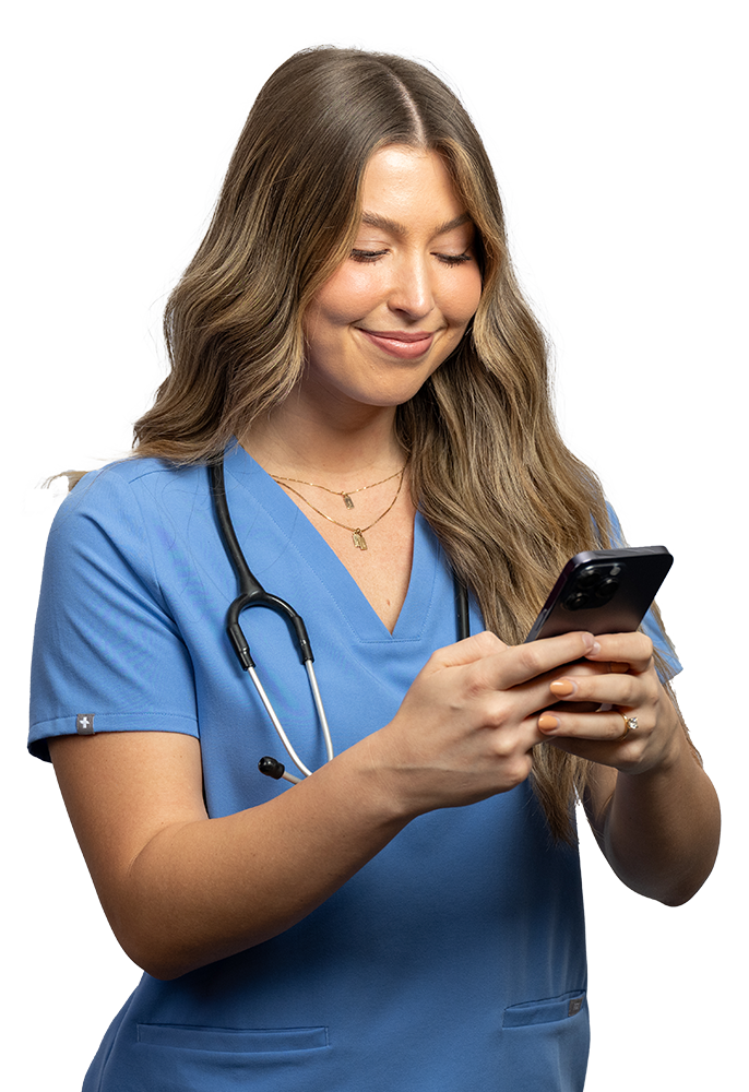 Female Healthcare worker in scrubs smiling using a phone